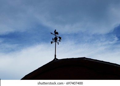 Antique Chicken Weathervane On A Roof.