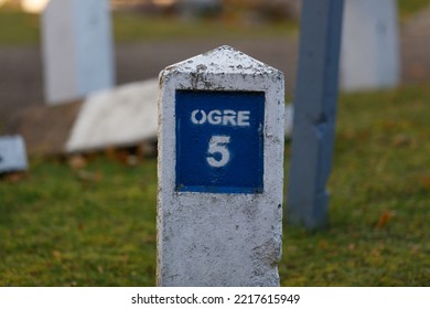 An Antique Concrete Road Mile Marker In White And Blue Showing 5 Kilometers To Ogre