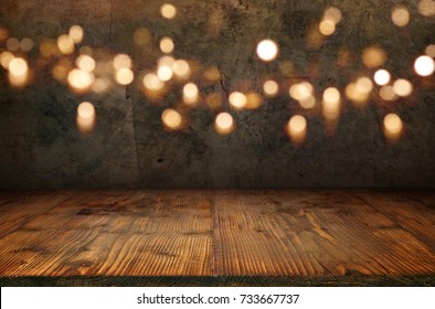 Antique concrete wall with golden bokeh and rustic wooden floor for a christmas decoration