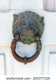 Antique Copper Door Knocker In The Form Of A Lion's Head On Wooden Door Close Up