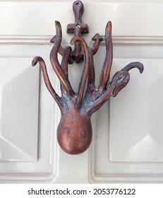 Antique Copper Door Knocker In The Shape Of An Octopus On A Wooden Door Close Up