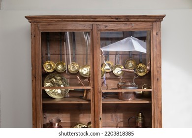 An Antique Cupboard With Copper And Brass Kitchen Utensils. Decoration Concept.