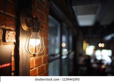 Antique Electronic Lamp, Red Wall Lamp, High Wall Lamp, Soft Light.Red Brick Wall.Open Chain, Turn Off The Lights.hanging At The Red Brick Wall In The Building,Wall Light Brown Brick,soft Focus.