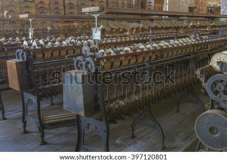 Antique equipment rusting on floor of turn of the century silk throwing factory.