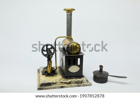 An antique Ernst Plank toy stationary steam engine on a plain background.