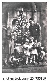 Antique Family Portrait Of Parents And Children With Christmas Tree. Vintage Picture With Original Film Grain And Blur. Black And White Photo