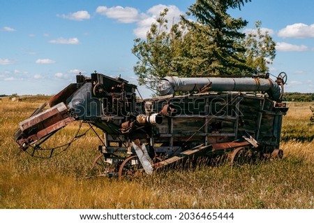 Antique farm equipment sitting in a field in Alberta. Grain thresher, threshing machine