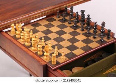 An Antique Fold Out Games Table That Has Multiple Games Inside It, With The Chess Set Currently Out. Isolated On A White Background.