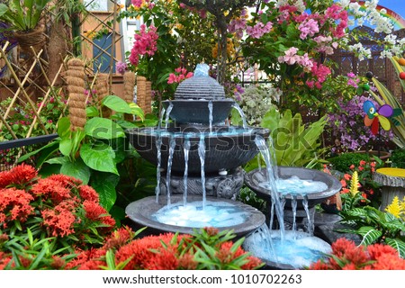 Antique fountain at garden. Blue water flowing from stone fountain. Design of antique fountain