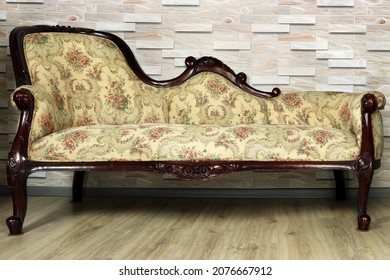 Antique furniture close-up. Sofa banquette in baroque style against the background of a wooden wall. - Shutterstock ID 2076667912