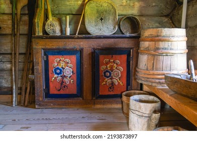 Antique Furniture And Household Items In A Rustic Log House Built In The 19th Century. The Interior Of An Old House. Dark Log Walls Of The House. Rustic Architecture.