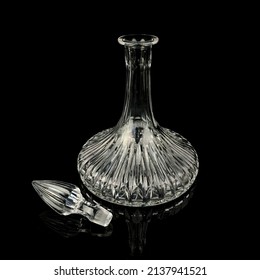 antique glass decanter with geometric pattern. retro decanter for alcohol on a black isolated background. engraved vintage decanter