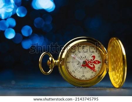 Antique gold clock. Isolated on a dark blue background. Symbol of time, old thing. Beautiful composition. There are no people in the photo. Advertising. Banner.