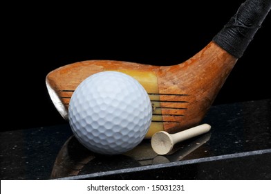 Antique Golf Club With Ball And Tee On Black Background