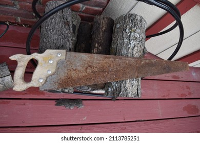 Antique Hand Saw On A Woodpile