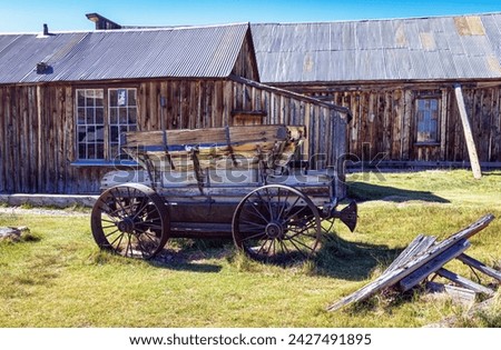 Antique horse drawn wagon and buildings in the Mining Ghost Town of Bodie State Park in the desert of California, USA.