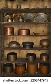 Antique Indian kitchenware collection on wooden shelf, Metal utensils ,pans, containers ,pots, kadhai made of copper, brass, and stainless steel  .