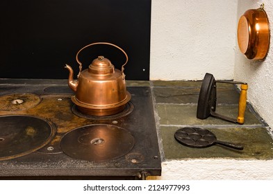 Antique Kitchen And Household Utensils, Some Made Of Copper, Were Placed For Decoration On A Traditional Kitchen Stove With Wood Or Coal Firing.