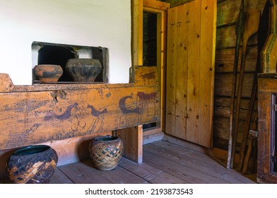 Antique Kitchen Utensils And Dishes Made In The 19th Century. The Interior Of The Kitchen And A White Oven In An Old House Built In The 19th Century. Rustic Architecture.