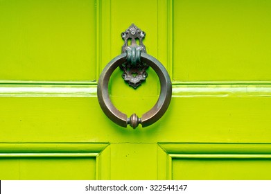 An Antique Knocker On A Lime Green Wooden Door