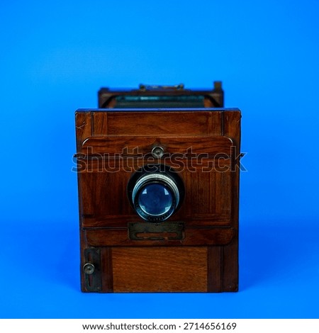 Antique Large Format Folding Bellows Camera Close-Up: Vintage Wooden Box Camera for Historic Photography and Collection on Isolated Blue Studio Background