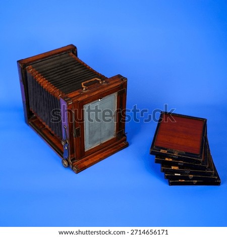 Antique Large Format Folding Bellows Camera Close-Up: Vintage Wooden Box Camera for Historic Photography and Collection on Isolated Blue Studio Background