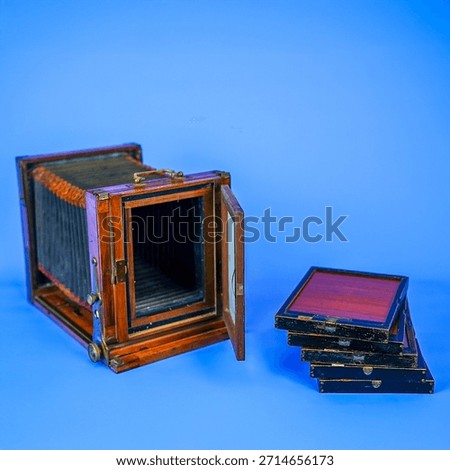 Antique Large Format Folding Bellows Camera Close-Up: Vintage Wooden Box Camera for Historic Photography and Collection on Isolated Blue Studio Background