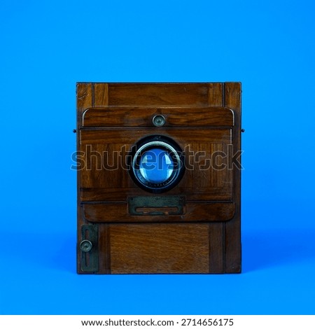 Antique Large Format Folding Bellows Camera Close-Up: Vintage Wooden Box Camera for Historic Photography and Collection on Isolated Blue Studio Background