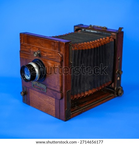 Antique Large Format Folding Bellows Camera Close-Up: Vintage Wooden Box Camera for Historic Photography and Collection on Isolated Blue Studio Background