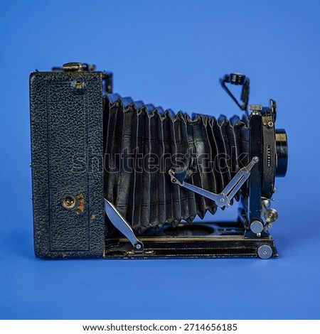 Antique Large Format Folding Bellows Camera Close-Up: Vintage Wooden Box Camera for Historic Photography and Collection on Isolated Blue Studio Background