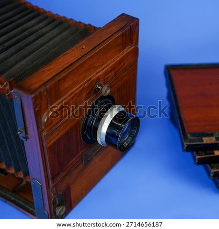 Antique Large Format Folding Bellows Camera Close-Up: Vintage Wooden Box Camera for Historic Photography and Collection on Isolated Blue Studio Background
