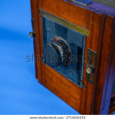 Antique Large Format Folding Bellows Camera Close-Up: Vintage Wooden Box Camera for Historic Photography and Collection on Isolated Blue Studio Background