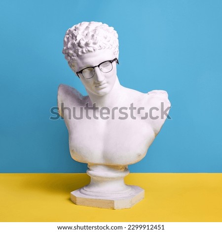 Antique male statue bust wearing glasses against blue yellow background. Education, business, knowledges. Concept of creativity, modernity and vintage, antique art. Inspiration and imagination