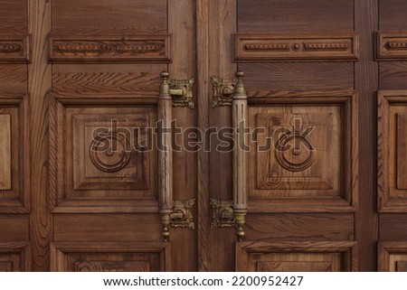 Antique massive wooden doors with large handles close-up. Ancient architecture