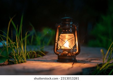 lámpara de aceite antigua en el antiguo parqué del bosque en la atmósfera de campamento nocturno