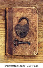 Antique Padlock With Key On Old Book