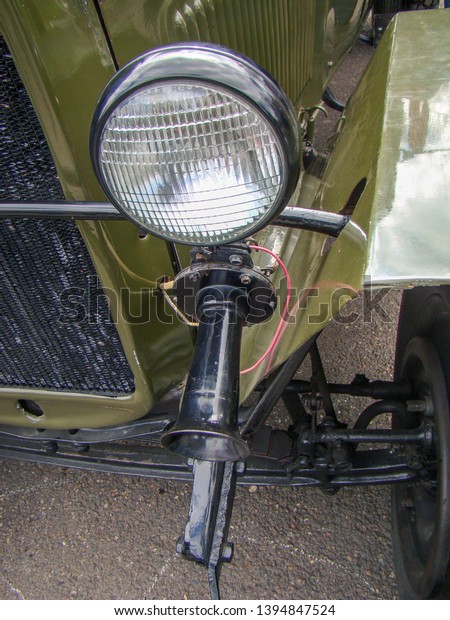 Antique passenger car. Green, Black color. Grille,\
headlight, horn, suspension components.                            \

