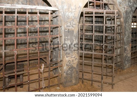 Antique prison cell with bars and bunks