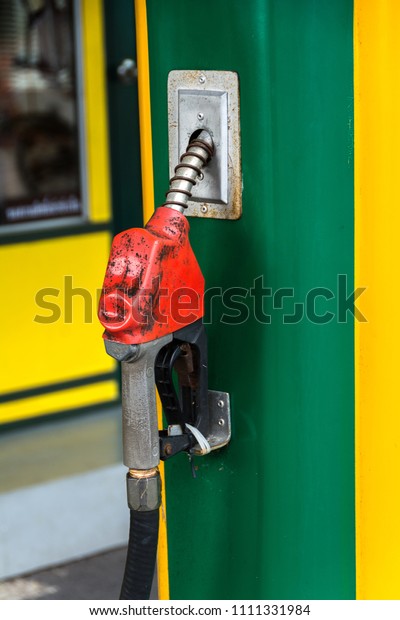 Antique Red Oil\
dispenser at the petrol\
pump