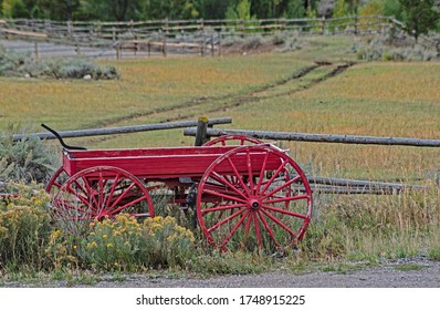 Antique Red Tractor Sits In The Landscape In The Grand Tetons.