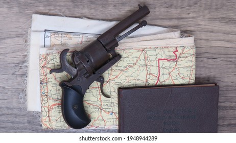 Antique Revolver Resting On Tattered Map