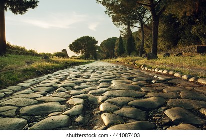 Antique road , Via Appia Antica in Rome, Italy on sunset