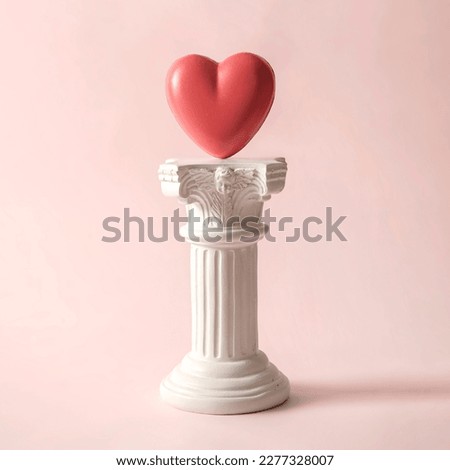 An antique Roman column with the symbol of the romantic heart. A minimal playful concept about a couple's love and relationship. High quality photo