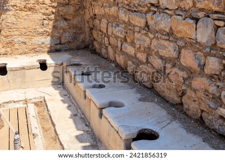 Antique Roman public toilet in the city of Ephesus. Background with selective focus and copy space for text