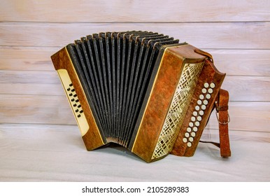 Antique Russian accordion on a light wooden background