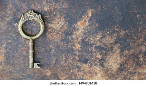 Antique rusty ornate key on grunge metal background, escape room game concept, web banner with copy space