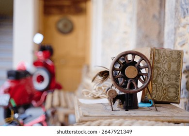 Antique sewing machine displayed in a rustic setting with a vintage scooter in the background. Detailed focus creates a nostalgic ambiance, blending handcrafted charm with historical significance.