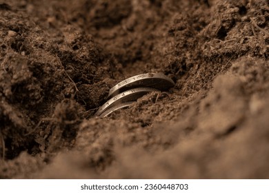 Antique silver coins sticking out of the ground. Search for jewels in the forest. An accidental find during construction.