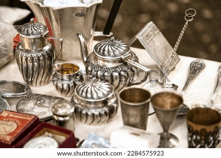 Antique silver teapots, creamer and other utensils at a flea market. Old metal tableware collectibles at a garage sale ストックフォト © 
