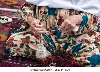 Antique spinning wheel in the hands of an old woman - Powered by Shutterstock